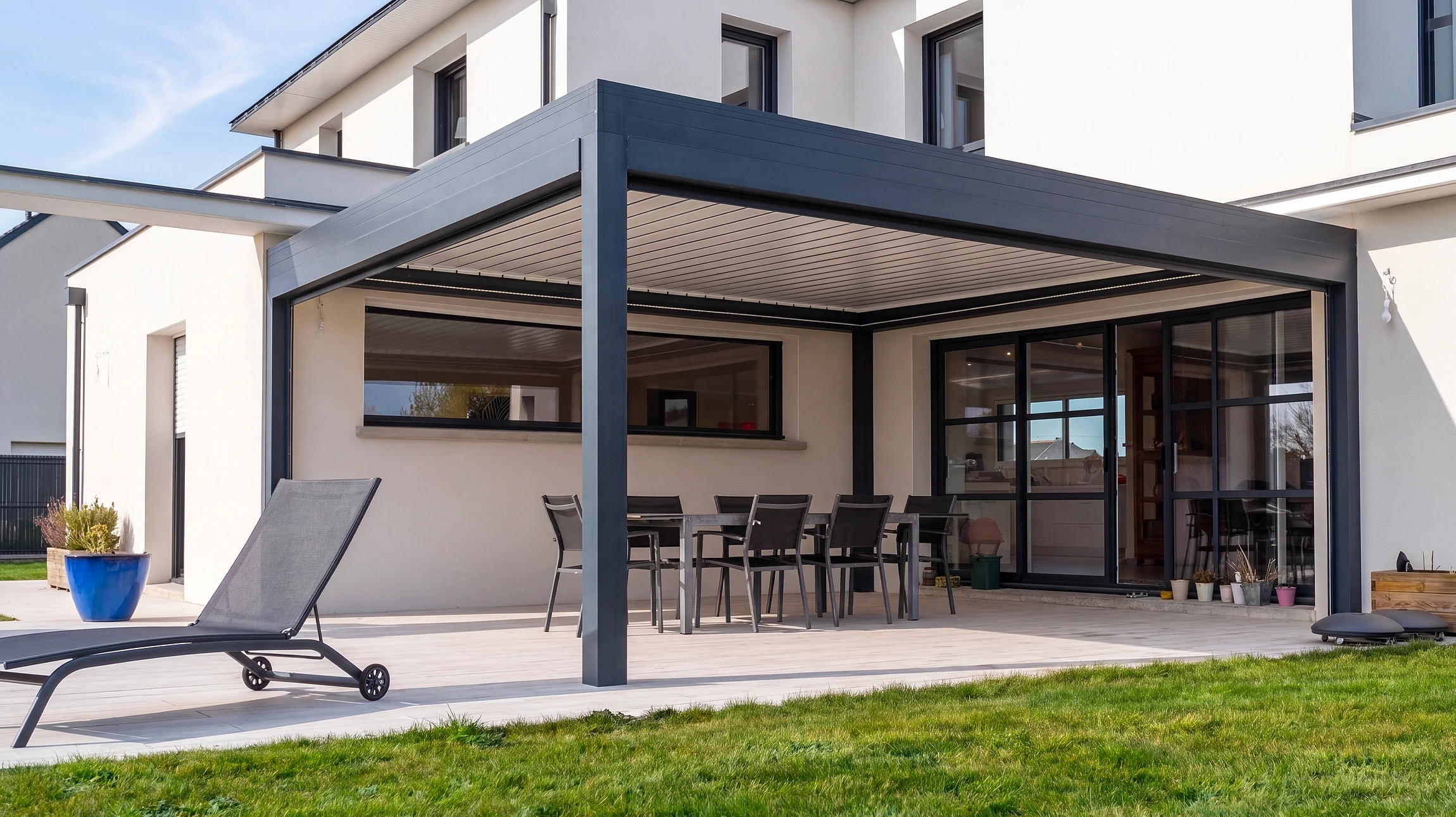 Terrasse extérieure moderne avec pergola contemporaine à structure métallique blanche et toiture plate ornée de tuiles orange-rouge