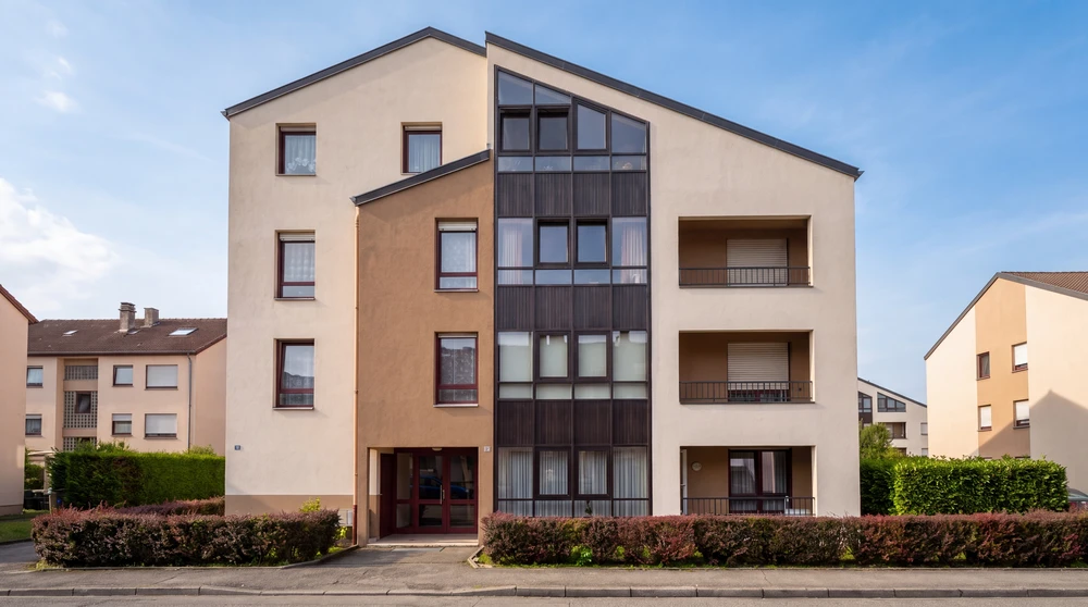 Deux techniciens sur une plateforme élévatrice ciseau jaune installent un faux plafond