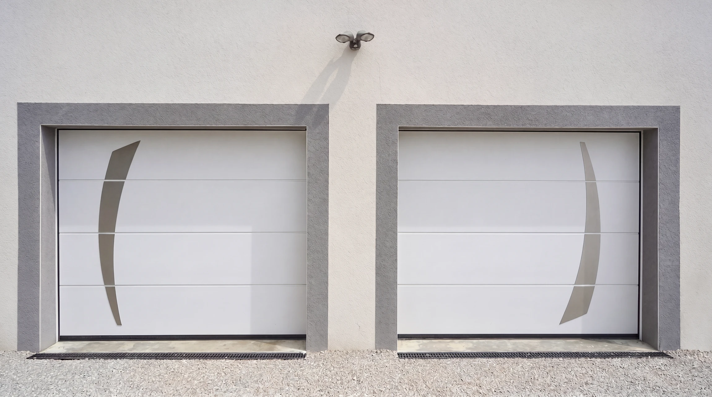 Porte de garage sectionnelle moderne en panneaux horizontaux gris anthracite, installée dans façade blanche contemporaine