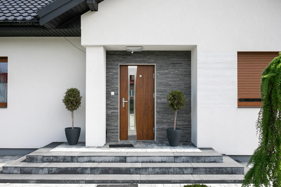 Entrée résidentielle moderne avec porte d'entrée en bois foncé à lignes verticales contemporaines